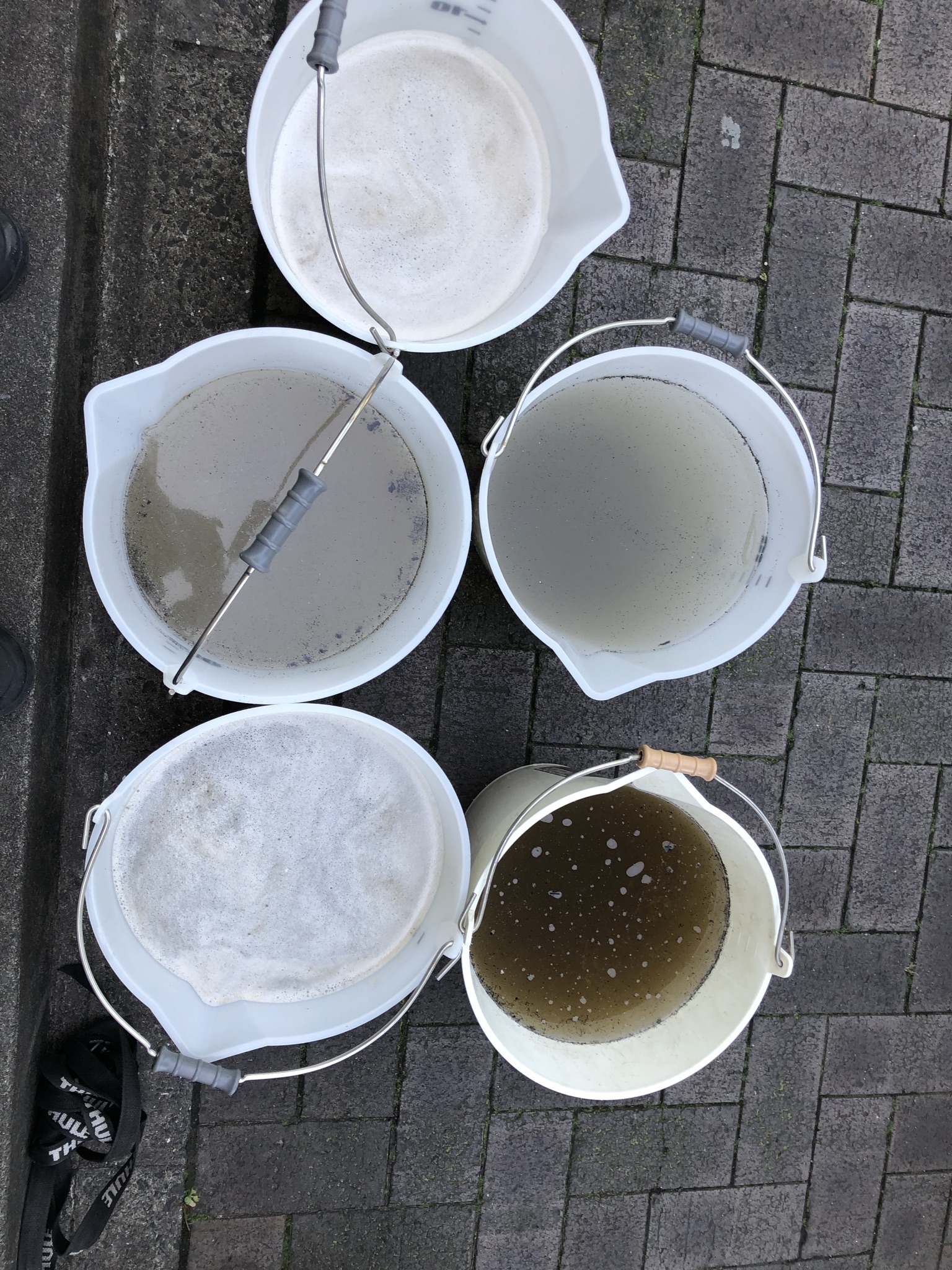 現場で使ったテラモトのじょうぶバケツを並べた写真。バケツ内の水の色や浮いた汚れ、容量目盛りが見える